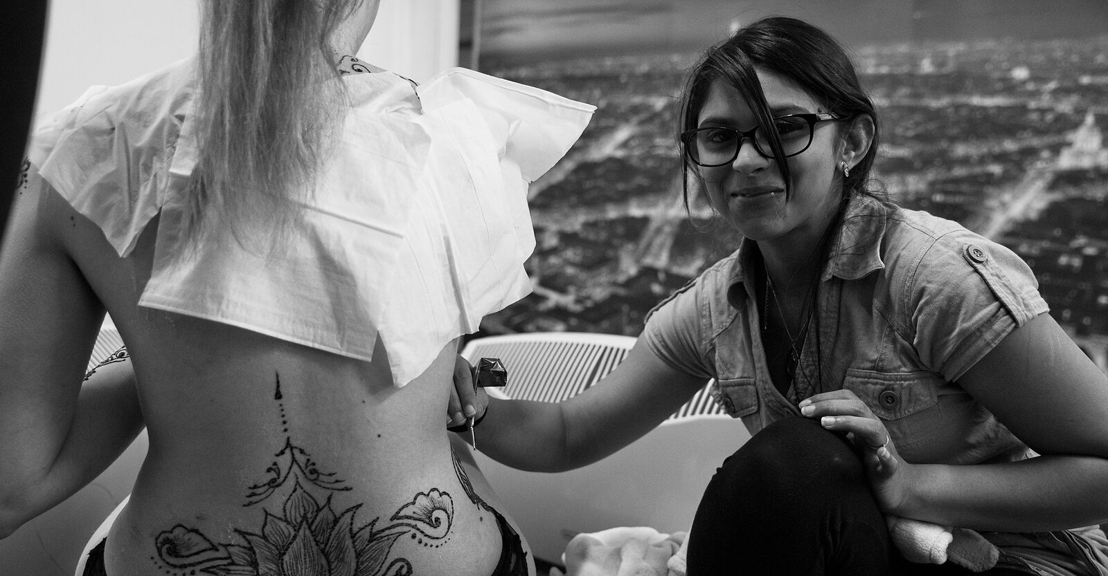 Saarah at work, drawing henna on a client's back