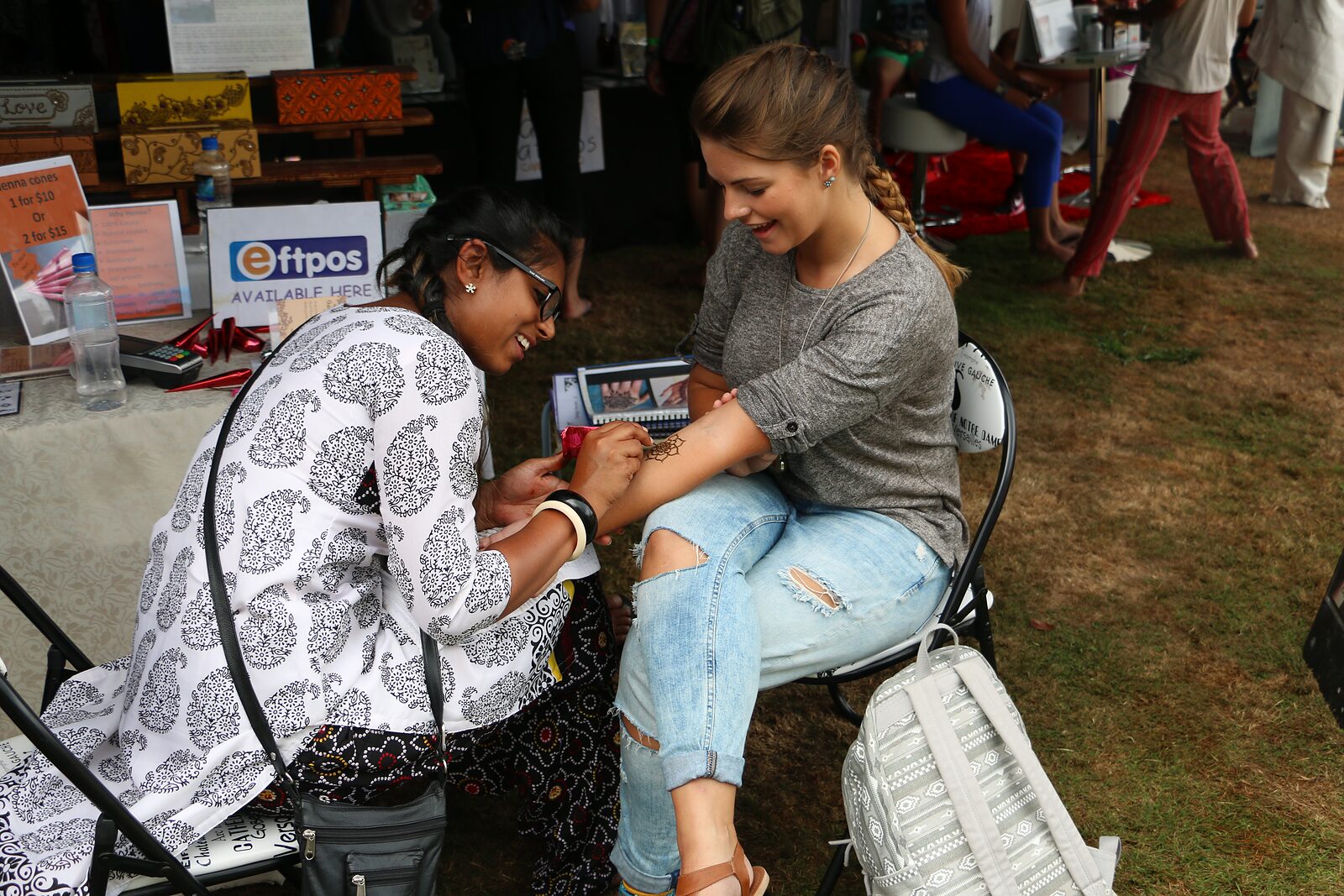 Saarah drawing henna for a guest at an event