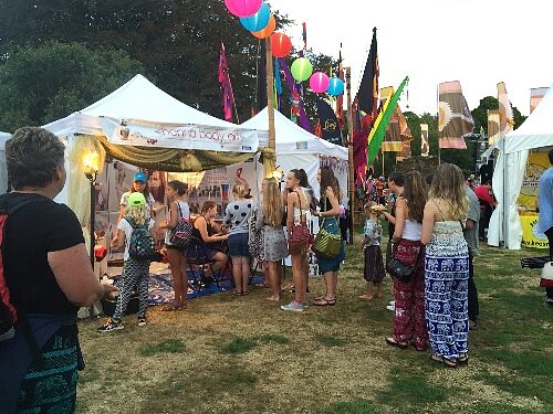 A festival crowd near the henna gazebo